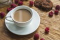 white cup coffee with chocolate cookies raspberries wooden background. High quality photo