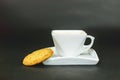 White cup of coffee with cookie on dark background Royalty Free Stock Photo