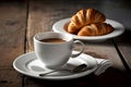 White cup with coffee and croissants