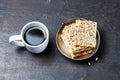 White cup with coffee and crunchy crispbread in a metal bowl on a wooden background, closeup Royalty Free Stock Photo
