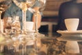 White cup of coffee on a glass table with glasses of wine Royalty Free Stock Photo