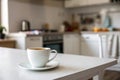 White cup of coffee on kitchen table Royalty Free Stock Photo
