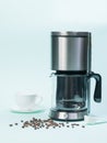 White Cup, coffee maker and coffee maker on blue background. Royalty Free Stock Photo
