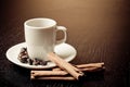 White cup with coffee near coffee beans over wood table Royalty Free Stock Photo
