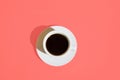 White Cup of Coffee with Saucer on trendy living coral color background. Top view. Morning energy fashion female business concept Royalty Free Stock Photo