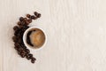 White cup of coffee and smile made of roasted coffee beans on light coloured wooden table Royalty Free Stock Photo