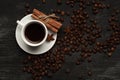 White cup with coffee sticks of cinnamon and anise on a black background with coffee beans and place for text top view Royalty Free Stock Photo