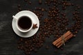 White cup with coffee sticks of cinnamon and anise on a black background with coffee beans and place for text top view Royalty Free Stock Photo