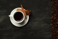 White cup with coffee sticks of cinnamon anise on a black background with coffee beans and place for text Royalty Free Stock Photo