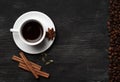 White cup with coffee sticks of cinnamon green cardamom and anise on a black background with coffee beans and place for text top Royalty Free Stock Photo