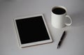 White cup of coffee on the office table and tablet with pen Royalty Free Stock Photo