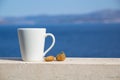 White cup with coffee and two figs on a background of blue sea and mountains Royalty Free Stock Photo