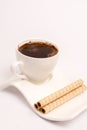 White cup of coffee with wafer chocolate cream rolls Royalty Free Stock Photo