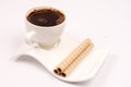 White cup of coffee with wafer chocolate cream rolls Royalty Free Stock Photo