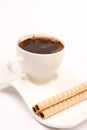 White cup of coffee with wafer chocolate cream rolls Royalty Free Stock Photo