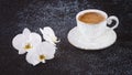 White cup of coffee and white orchid flowers. Romantic composition in white on a black background Royalty Free Stock Photo