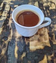 white cup with double espresso on a charred wood plank background Royalty Free Stock Photo