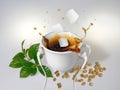 A white cup with white earphones put on it and splash of coffee with three sugar cubes Royalty Free Stock Photo