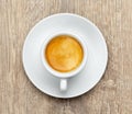 White cup of espresso coffee with creams on a wooden table, top view Royalty Free Stock Photo