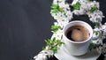 White cup of espresso coffee on a stone table, white cherry blossoms, springtime Royalty Free Stock Photo