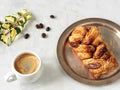 White cup with espresso next to maple pecans with nuts and syrup. Fresh coffee beans, ivy branch. Located on a gray background. Royalty Free Stock Photo