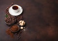 White cup of fresh raw organic coffee with beans and ground powder with cane sugar cubes with coffee tree leaf on brown background Royalty Free Stock Photo