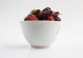 White cup with fresh sweet mulberries  berries and green leaf isolated on white Royalty Free Stock Photo