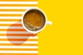 White cup of freshly brewed coffee with foamy crema on duotone yellow white striped background. Top view. Morning breakfast energy Royalty Free Stock Photo