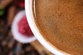 White cup full of coffee beans on a coffee beans background with red chocolate candy and red flowers. Morning espresso. Coffee mug Royalty Free Stock Photo