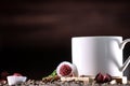 White cup full of coffee beans , red flowers and red chocolate candy against the background of a red wood wall. Royalty Free Stock Photo