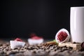 White cup full of coffee beans , red flowers and red chocolate candy against the black background. Morning espresso. Royalty Free Stock Photo