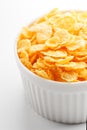 White cup with golden corn flakes isolated on white background. View from above. Delicious and healthy breakfast Royalty Free Stock Photo