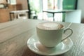 A white cup of hot cappuccino with beautiful cafe`s interior Royalty Free Stock Photo