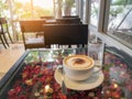 A white cup of hot cappuccino coffee with white mug topping and a glass of water, on glassed top black table Royalty Free Stock Photo