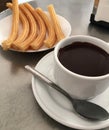 Cup with hot chocolate and churros plate