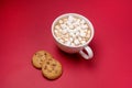 White Cup of Hot Chocolate Cocoa with Marshmallows on Red Background Tasty Cookies with Chocolate lying on Red Background Top View