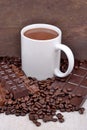 White cup of hot chocolate on coffee beans and chocolate background Royalty Free Stock Photo