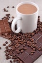 White cup of hot chocolate on coffee beans and chocolate background Royalty Free Stock Photo