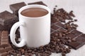 White cup of hot chocolate on coffee beans and chocolate background Royalty Free Stock Photo