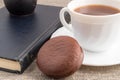 White cup of hot chocolate, old book and chocolate biscuit Royalty Free Stock Photo