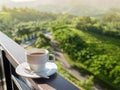 White cup of hot coffee on balcony with natural and mountains. Royalty Free Stock Photo