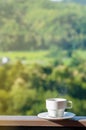 White cup of hot coffee on balcony with natural and mountains. Royalty Free Stock Photo