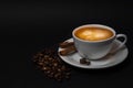 White cup of hot coffee, cinnamon sticks, coffee beans on black background Royalty Free Stock Photo