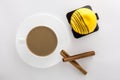 White cup of hot coffee and Cinnamon sticks and Mango sweet cake Royalty Free Stock Photo
