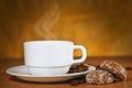 White cup of hot coffee on a saucer and two cakes Royalty Free Stock Photo