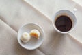 white cup of hot coffee served with two small mooncake on table with vintage tone. Break times concept Royalty Free Stock Photo