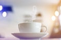 White cup of hot coffee with steaming on table with bokeh background at coffee shop Royalty Free Stock Photo