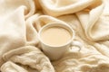 The white cup of hot coffee or tea with milk and the ivory color warm scarf Royalty Free Stock Photo