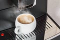 White Cup with hot cooked on the expresso coffee machine Royalty Free Stock Photo