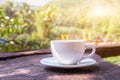 A white cup of hot espresso coffee mugs placed on a wooden floor with morning fog and moutains with sunlight background,coffee Royalty Free Stock Photo